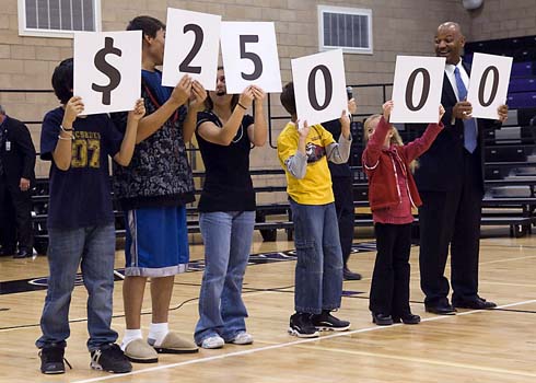 Discovery Canyon Campus Colorado Commissioner of Education Dwight D. Jones (right) helps Discovery Canyon Campus students hold up cards displaying the amount of the Milken Educator Award, which is about to go to one of their outstanding teachers.