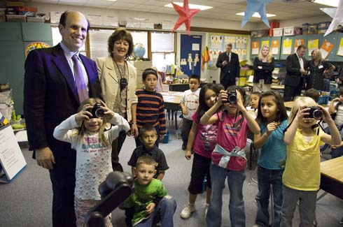 Empire Elementary School Milken Institute Chairman Michael Milken visits new Milken Educator Gayle Magee's classroom, as her students hold up the digital cameras they use in their learning projects.