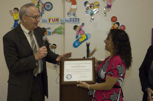 Horace Mann Dual Language Magnet School Kansas Deputy Commissioner of Education Dale M. Dennis presents a special plaque from the Kansas Department of Education honoring Vanessa Martinez for her $25,000 Milken Educator Award.