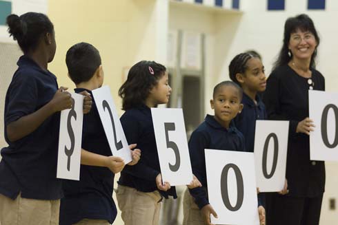 Nellie Stone Johnson Community School With help from Milken Family Foundation Trustee Joni Milken-Noah (far right), students at Nellie Stone Johnson Community School hold up cards displaying the amount of the Milken Educator Award, which will go to one of their outstanding educators.