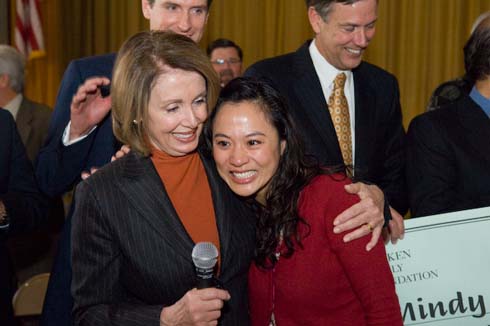 Visitacion Valley Elementary School House Speaker Nancy Pelosi gives a congratulatory hug to first-grade teacher Mindy Yip, the surprise recipient of a $25,000 Milken Educator Award.  Behind them are San Francisco Mayor Gavin Newsom and California Superintendent of Public Instruction Jack O'Connell.