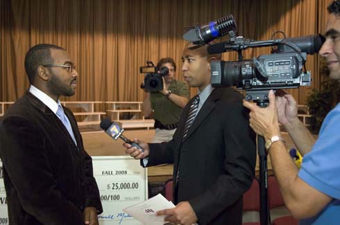 F. B. Woodley Elementary School Aaron Wilson is interviewed by a local TV reporter about being surprised with a $25,000 Milken Educator Award.